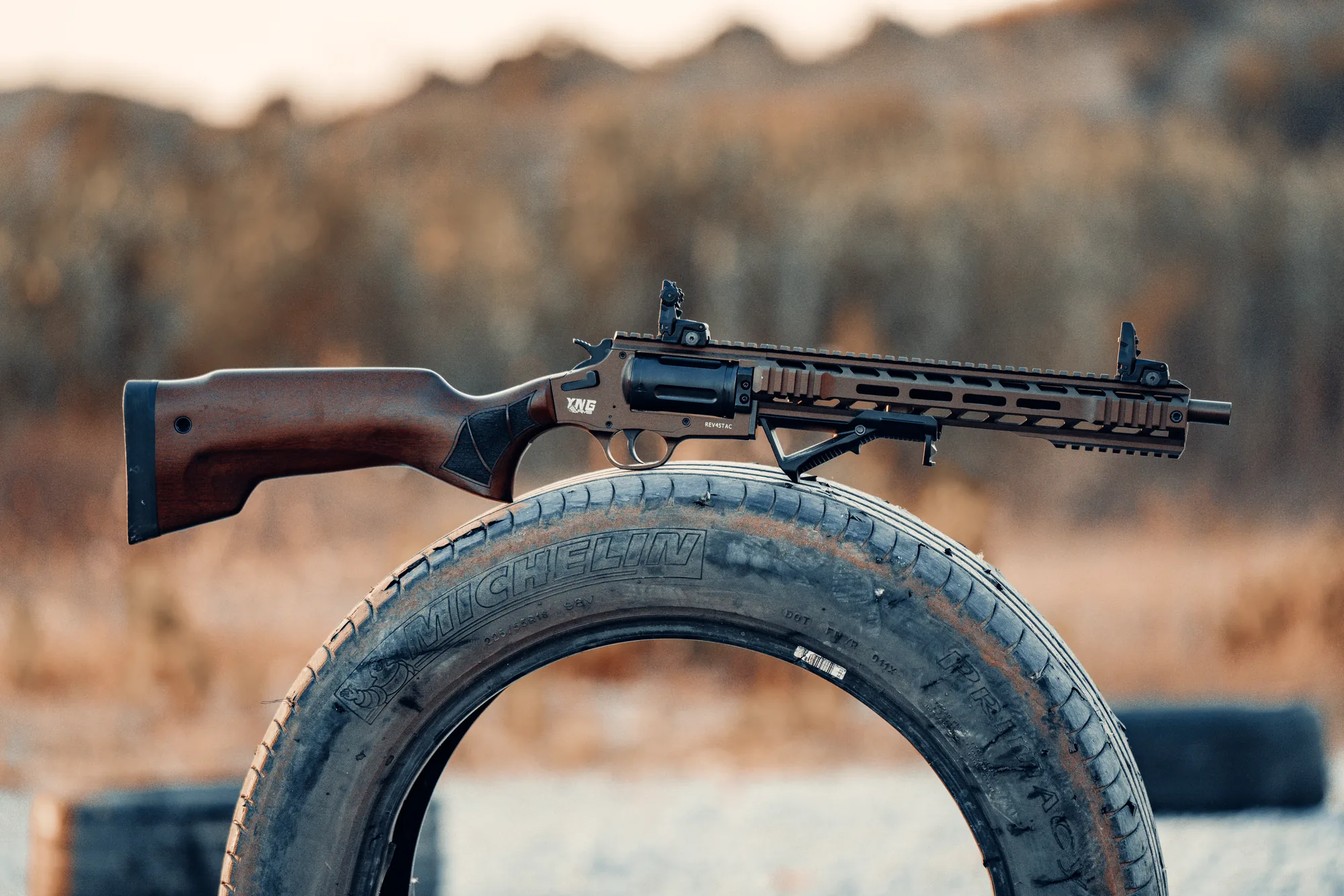 A walnut-stock rifle resting on a spare wheel